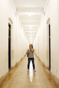 Mid adult man standing in corridor