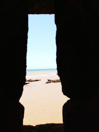 Scenic view of sea against clear sky seen through cave