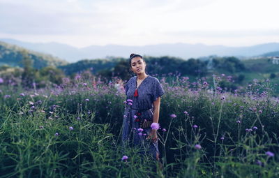 Full length of woman standing on field against sky