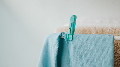 Close-up of laundry hanging on clothesline against wall