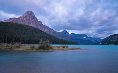 Scenic view of lake by mountains against sky