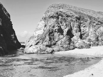 Rock formations by sea against sky