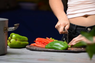 Midsection of woman holding fruit on table