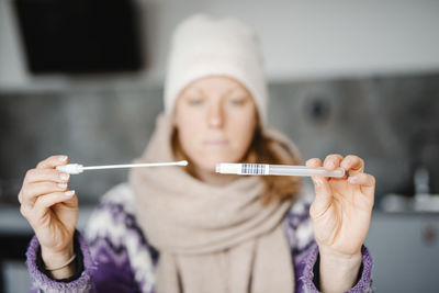 Woman holding swab and medical tube for covid19 home test