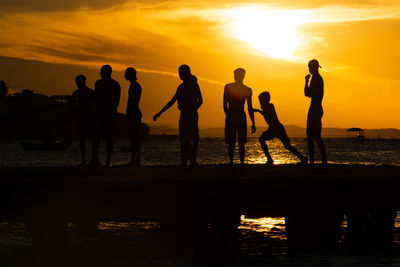 Silhouette people at beach during sunset