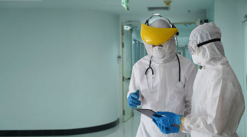 The doctor in the ppe protective suit asked the patient for information to test covid-19 infection.