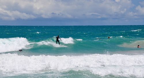 Man surfing in sea against sky