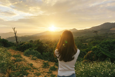 Rear view of woman at sunset