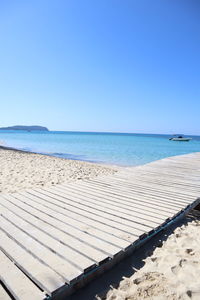 Scenic view of beach against clear blue sky