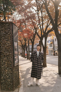 Portrait of smiling man standing by tree