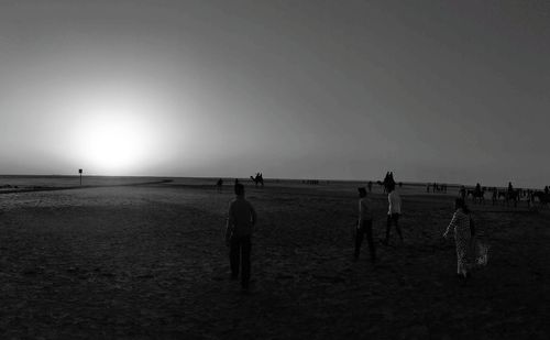 People on beach against clear sky