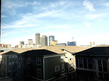 View of cityscape against cloudy sky