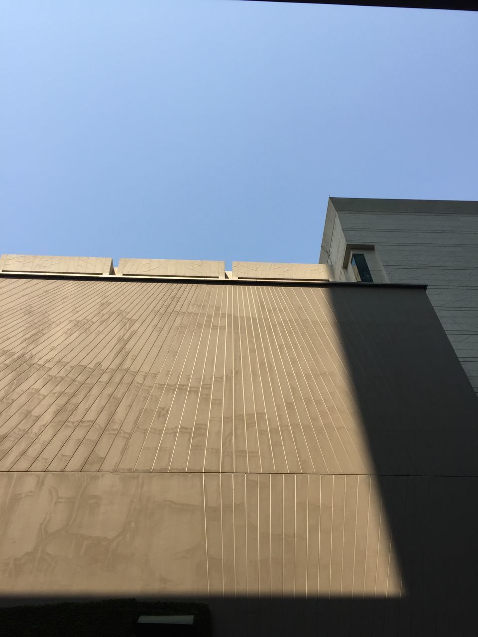 LOW ANGLE VIEW OF BUILDING AGAINST BLUE SKY