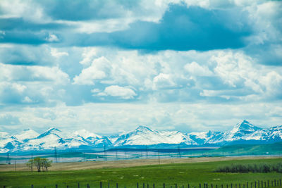 Scenic view of field and mountains against sky