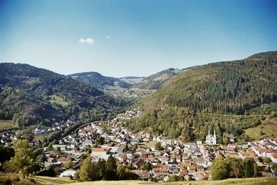 Aerial view of townscape and mountains against sky