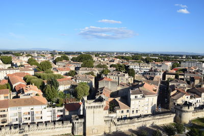 High angle view of houses in town against blue sky