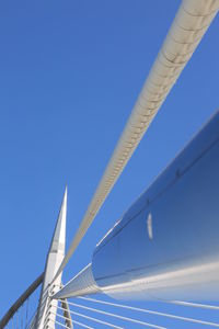 Low angle view of suspension bridge against clear blue sky