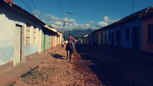 People walking on street amidst buildings in city