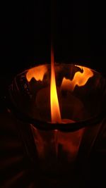 Close-up of burning candle in darkroom