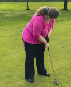 Rear view of boy playing on golf course