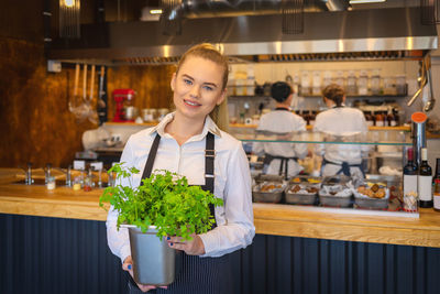 Portrait of a smiling young woman holding food