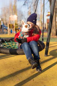 Low section of woman sitting on swing