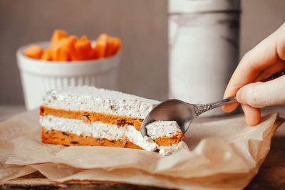 Close-up of hand holding ice cream on table