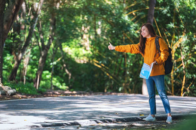 Full length of young woman walking in forest