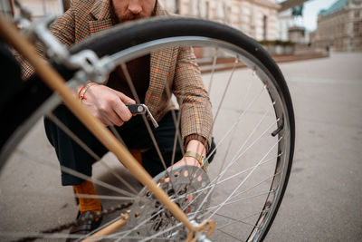 Man checking wheels on bike. repairing bicycle at street.