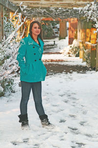 Portrait of a smiling woman standing in snow