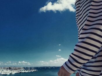 Close-up of man on beach against blue sky