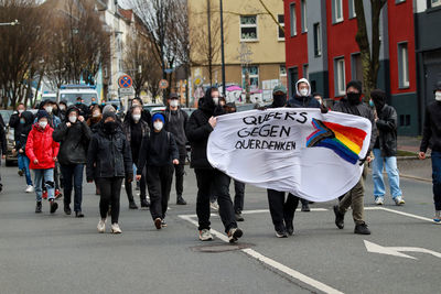 Group of people walking on road along buildings