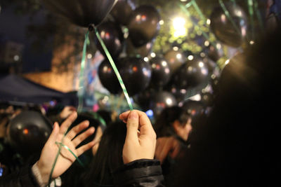 Midsection of woman holding illuminated lights at music concert