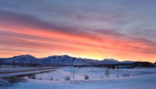Scenic view of snow covered mountains against sky during sunset