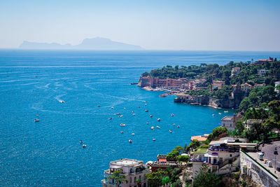 High angle view of buildings by sea against sky