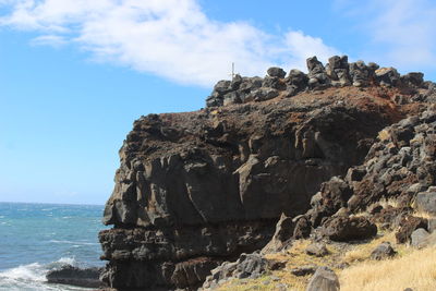 Rock formations by sea against sky