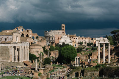 Old buildings in city against cloudy sky