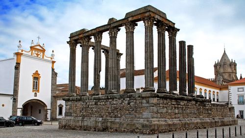 Roman temple of evora by igreja sao joao evangelista against sky