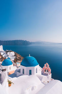 Panoramic view of sea and buildings against blue sky