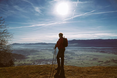 Woman standing on landscape against sky