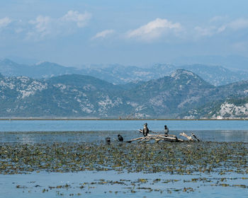 Scenic view of sea and mountains against sky