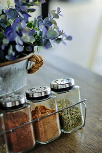 Condiment set with a vase of flowers on the table.