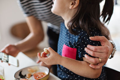 Midsection of woman holding ice cream at home