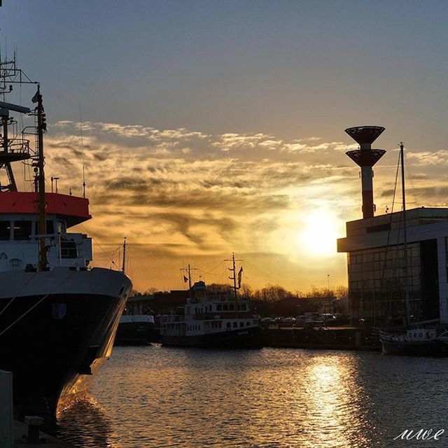 sunset, nautical vessel, transportation, water, mode of transport, waterfront, building exterior, architecture, boat, built structure, moored, sky, harbor, sea, orange color, cloud - sky, river, crane - construction machinery, sun, city