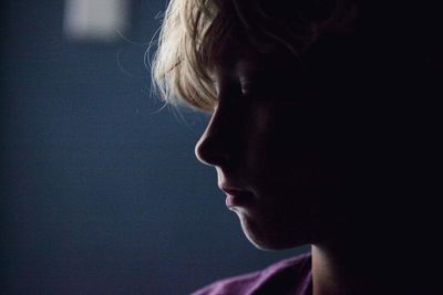 Side view of a girl against black background