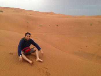 Full length of man on sand dune in desert