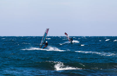 Scenic view of people on sea against sky