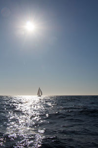 Sailboat sailing on sea against sky