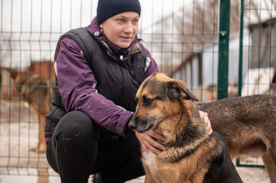 Girl volunteer in the nursery for dogs. shelter for stray dogs.