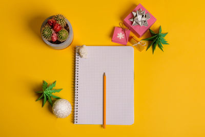 High angle view of pencil on table against yellow background